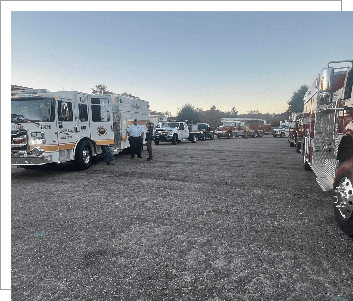Firefighters near parked emergency vehicles